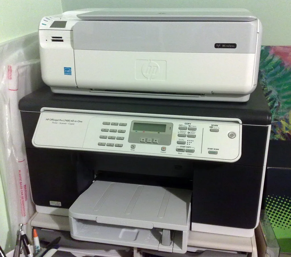 HP OfficeJet printer with output tray open showing cartridge area