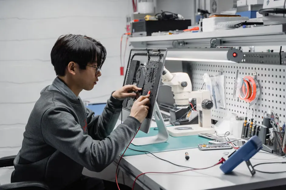 Technician working on an office multifunction printer, focused on internal components